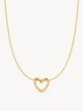 A delicate gold chain necklace featuring a small, open heart-shaped pendant with a polished finish, shown against a plain off-white background.