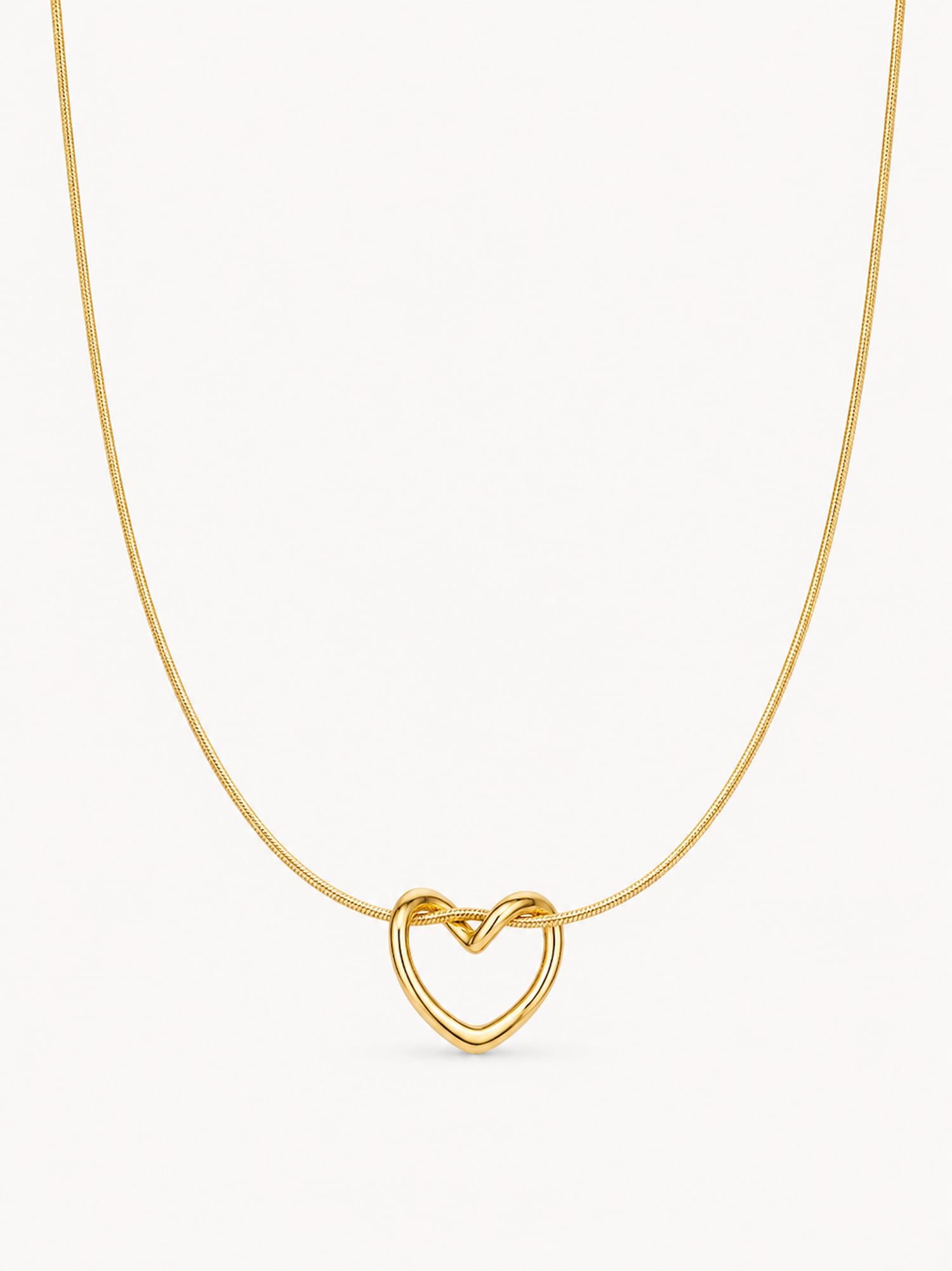 A delicate gold chain necklace featuring a small, open heart-shaped pendant with a polished finish, shown against a plain off-white background.