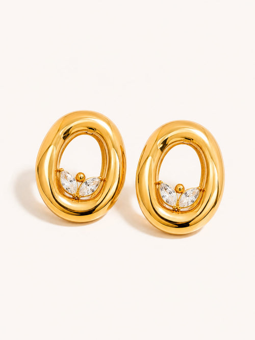 Gold oval drop earrings featuring marquise-cut clear cubic zirconia accents in a sculptural open-frame design.