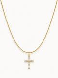 Gold snake chain necklace featuring a sparkling CZ cross pendant with white stones.