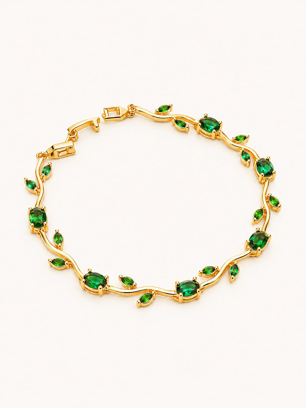 Emerald tulip chain bracelet with elegant green stones in a flowing gold design.