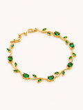 Emerald tulip chain bracelet with elegant green stones in a flowing gold design.