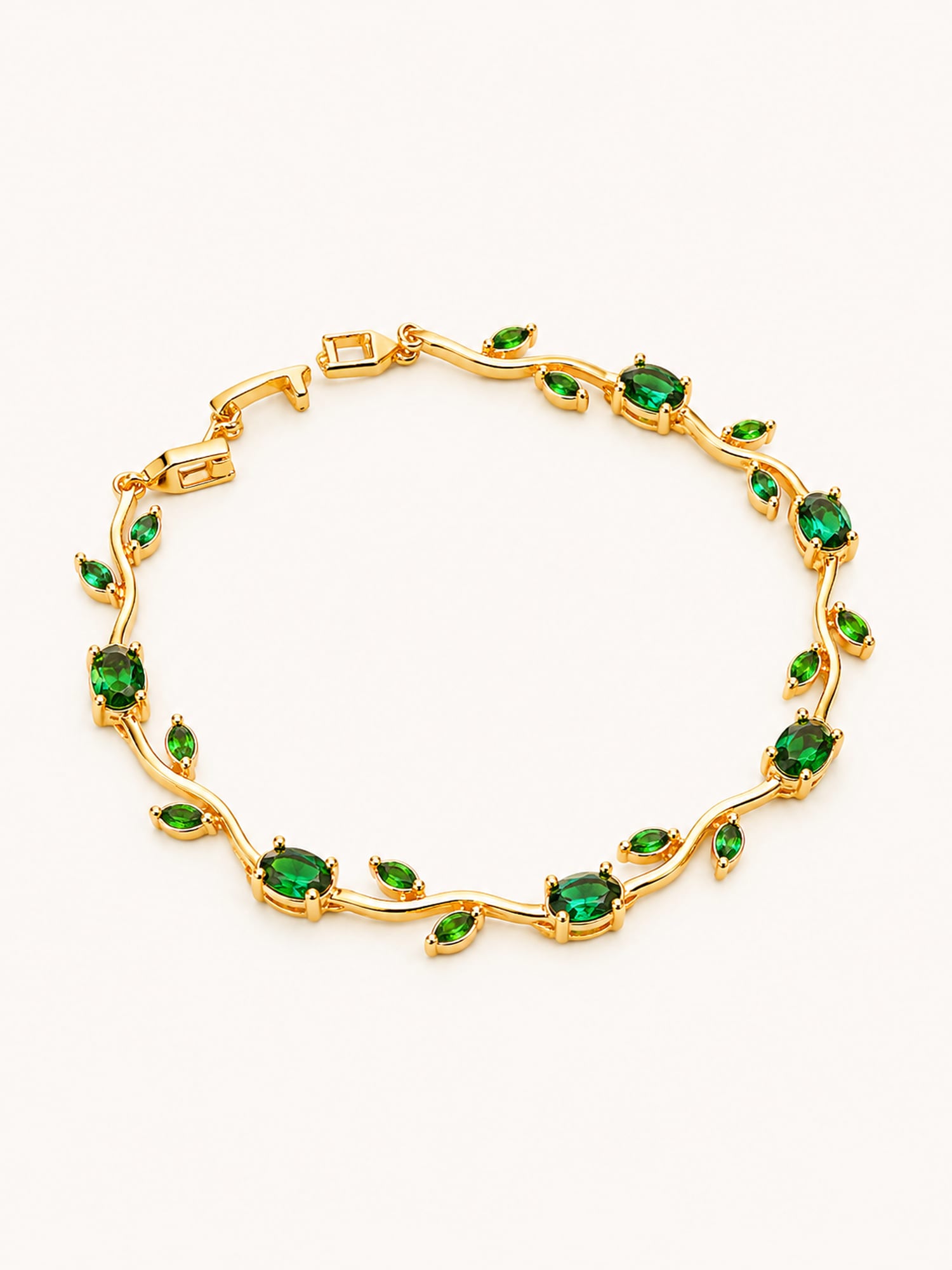 Emerald tulip chain bracelet with elegant green stones in a flowing gold design.