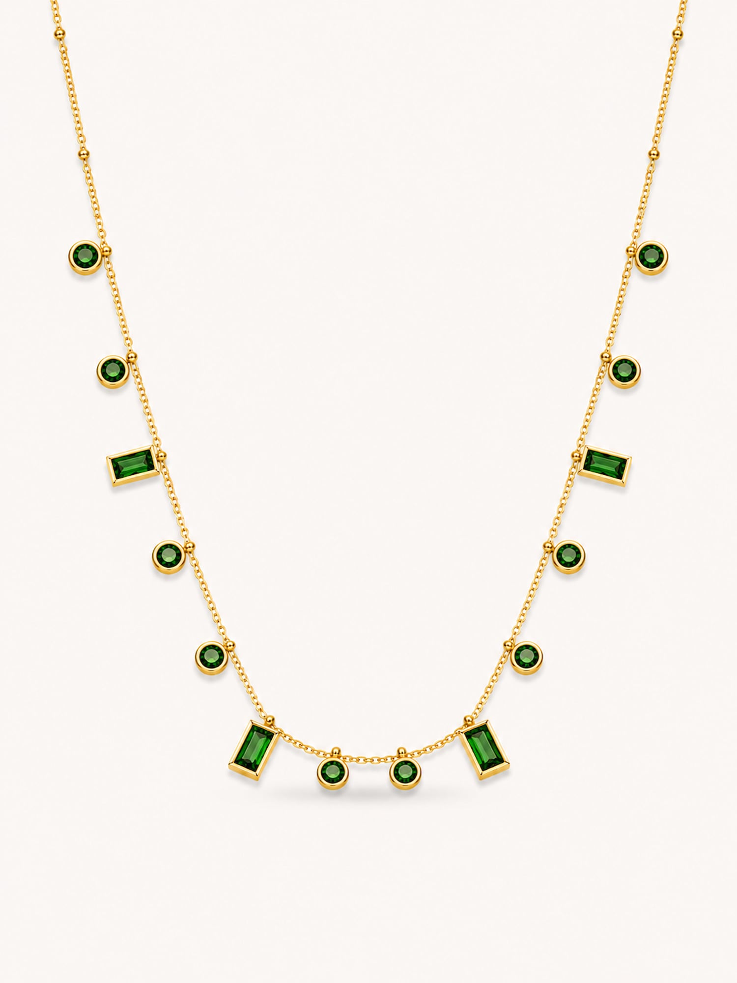 Green CZ station necklace featuring alternating round and baguette-cut stones in an 18K gold plated stainless steel chain.