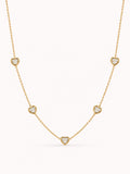 Minimalist heart CZ station necklace with five bezel-set white stones in a polished gold finish.