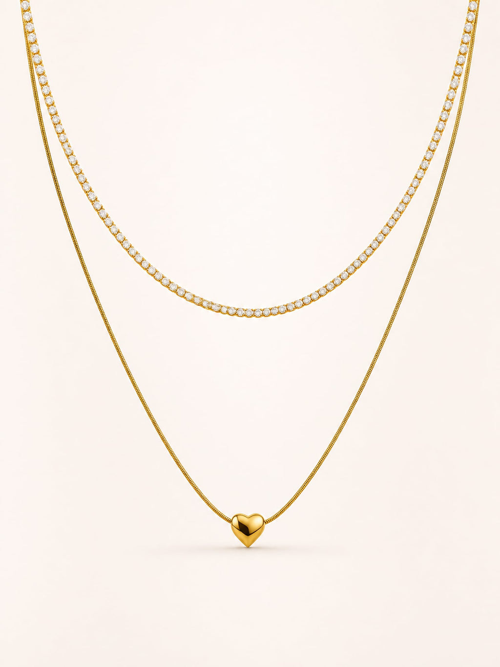 Layered heart necklace featuring a polished heart pendant and sparkling white CZ tennis chain in 18K gold plated stainless steel.