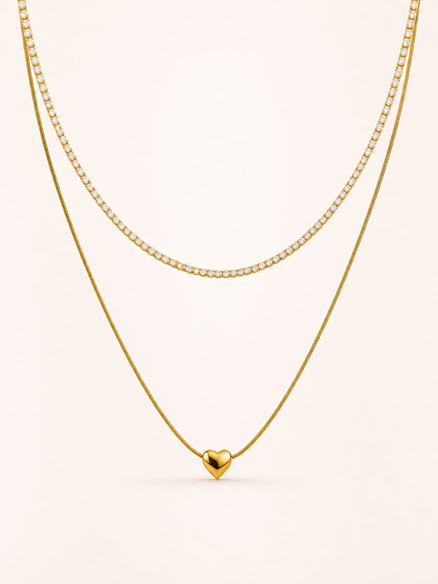 Layered heart necklace featuring a polished heart pendant and sparkling white CZ tennis chain in 18K gold plated stainless steel.